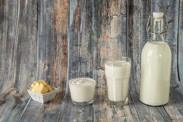 Milk kefir sour cream and butter are in a row on a wooden background. Fresh dairy products for breakfast