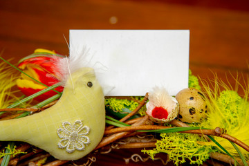 a close-up of spring tender composition of flowers, green moss, feathers and hand made birds, mockup of card