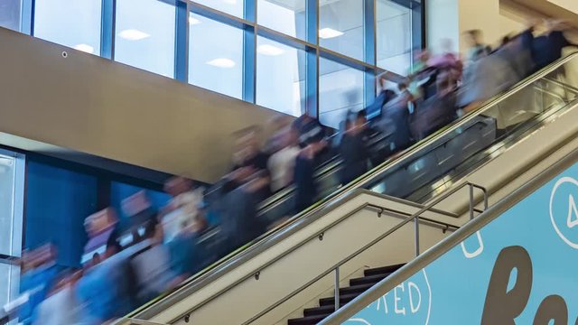 Time lapse of fast moving blurred people going up and down an escalator or escalators at shopping mall.