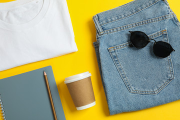 Flat lay composition with women clothes and creative accessories on yellow background. Inspiring backdrop, closeup © Atlas