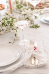 Laying and decor of the wedding banquet table. Plates, knives, forks, glasses, plates, flowers, snacks and fruit. The main thing in the details.