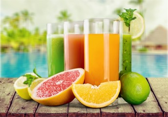 Tasty fruits  and juice with vitamins on background