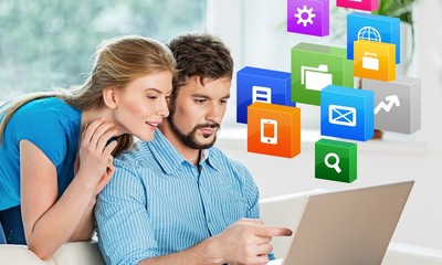 Portrait of cheerful Couple on the couch using laptop