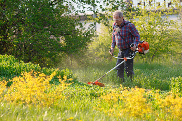 man mows the lawn grass with a lawn mower.