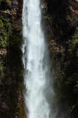 Fototapeta premium Selective focus on Water curtain with Dark moss in the background. Long exposure shot. 