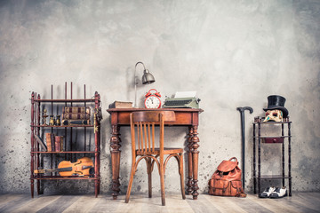 Room interior with antique chair, old typewriter, lamp, retro clock on wooden desk, books,...