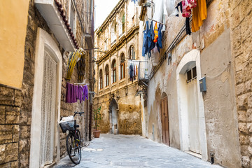 Bari, Italy - March 12, 2019: People walking through the alleys of the old city of Bari.