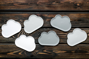 cloud service concept with clouds on wooden background top view