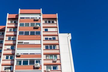 a rear view corner shoot of a tall building with blue background