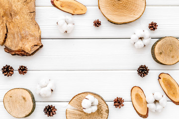 sawcut, immortelle and pine cone frame for blog on white wooden background top view space for text