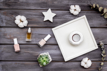 Work desk design with concrete decorations, nail polish and perfume on wooden background top view