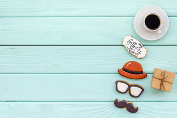 moustache, hat, glasses, coffee, gift and copy for Happy Father Day party on mint green background top view copy space