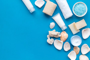 spa organic cosmetics, cream, lotion, salt, soap with Dead Sea minerals on blue background flat lay space for text