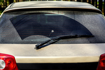 rear window hatchback dirty car rear view on a dusty glass in bird droppings.