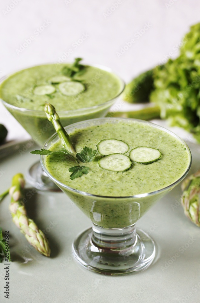 Wall mural soup puree from avocado, asparagus and cucumber. Dietary detox diet. Vegetarian dish. serving soup in a glass bowl.