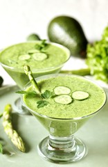 soup puree from avocado, asparagus and cucumber. Dietary detox diet. Vegetarian dish. serving soup in a glass bowl.
