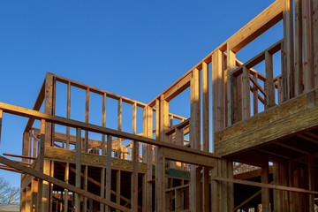 Close-up of beam built home under construction and blue sky with wooden truss, post and beam framework. Timber frame house, real estate background