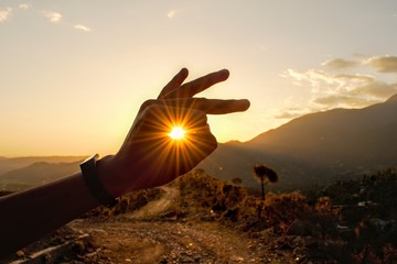 sunset in mountains between hand 