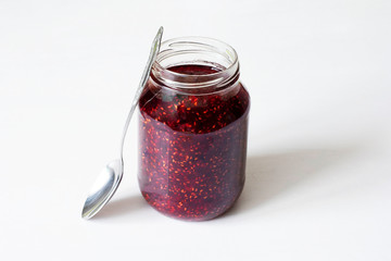 Glass jar with red jam on the table