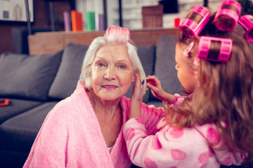 Aged lady feeling good having beauty day with granddaughter