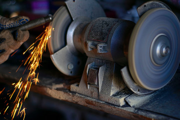 Closeup of a man grinding metal, manufacturing tool industry