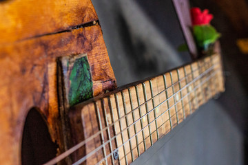 old guitar on concrete wall background with blurred front and back background with bokeh effect