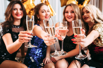 Hen party. Girls holding glasses with champagne, congratulating friend with upcoming special day,...