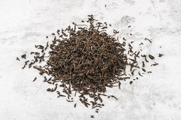 Dried tea is piled on a marble table.