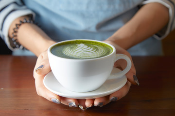 Woman holding Matcha green tea latte