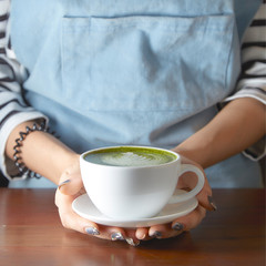 Woman holding Matcha green tea latte