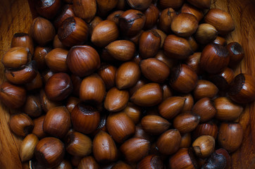 hazelnuts scattered on boards, photographed from above, forming a uniform background