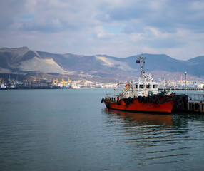 Fototapeta premium Amazing view on a harbor with great mountains behind the boat