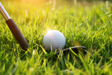 Golf ball and golf club in beautiful golf course at sunset background.