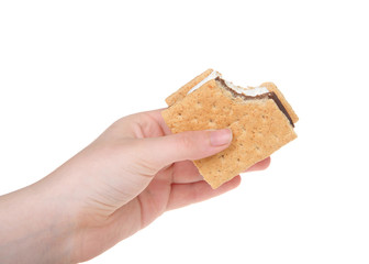 Young caucasian female hand holding s'more with bite missing, isolated on white background