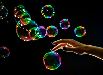 The transparent, iridescent soap bubbles isolated on black.