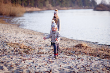 A boy and a girl  having fun outside in early spring in the forest near the water. A sister and brothe together. Friendship and  family concept