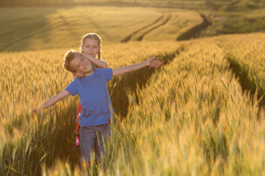 concept, children, a boy and a girl go to a wheat field, rejoice and have fun, gestures and emotions