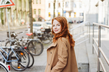 Young redhead girl in the street, looking back