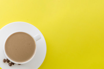 White cup of hot coffee isolated on Yellow background.