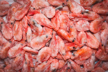 Raw shrimp background. Pile of frozen shrimps on white background.Close-up of frozen shrimps. Shrimp and ice, top view.