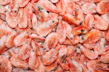 Raw shrimp background. Pile of frozen shrimps on white background.Close-up of frozen shrimps. Shrimp and ice, top view.