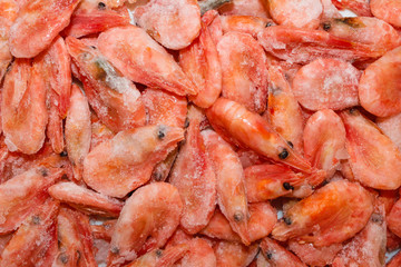 Raw shrimp background. Pile of frozen shrimps on white background.Close-up of frozen shrimps. Shrimp and ice, top view.