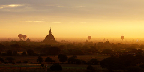 Obraz premium Sunset in buddhist temple,stupa,in the historical park of Bagan,Myanmar with air balloon in the sky