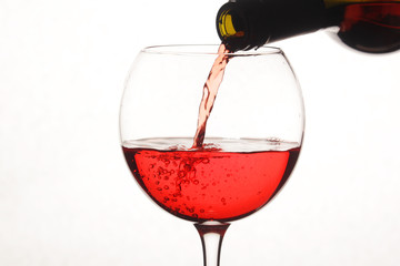 Bright red cocktail pouring to a glass from a bottle	