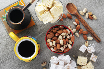 A mug of coffee and different oriental sweets: turkish delight, halva, almond and pistachio