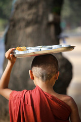 Fototapeta na wymiar Novice monks recept alms in the historical park of Bagan,Myanmar
