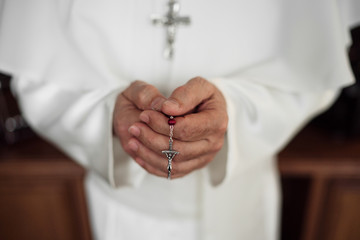 Hands of an papa holding rosary beads