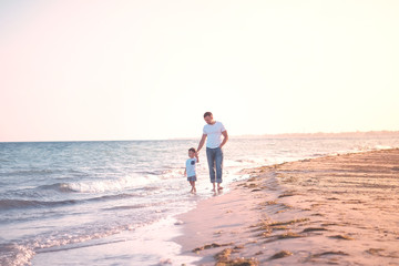 dad and child on  beach