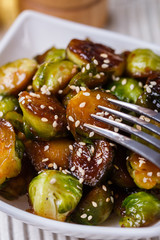Roasted Brussels sprouts in a white bowl on a wooden background