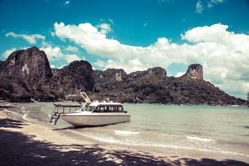 Snow white luxury speedboat on the shore of a tropical island. Moored on a sandy beach, Tropics and...